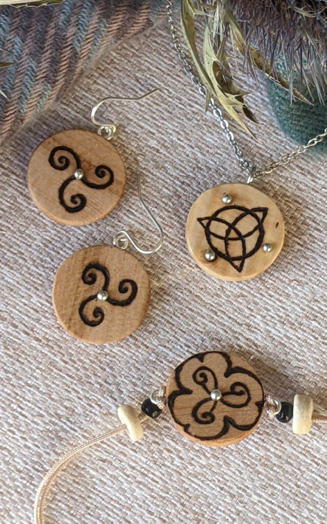 bijoux en bois clair avec pyrogravure de symbole celtique, triketra, trisquel