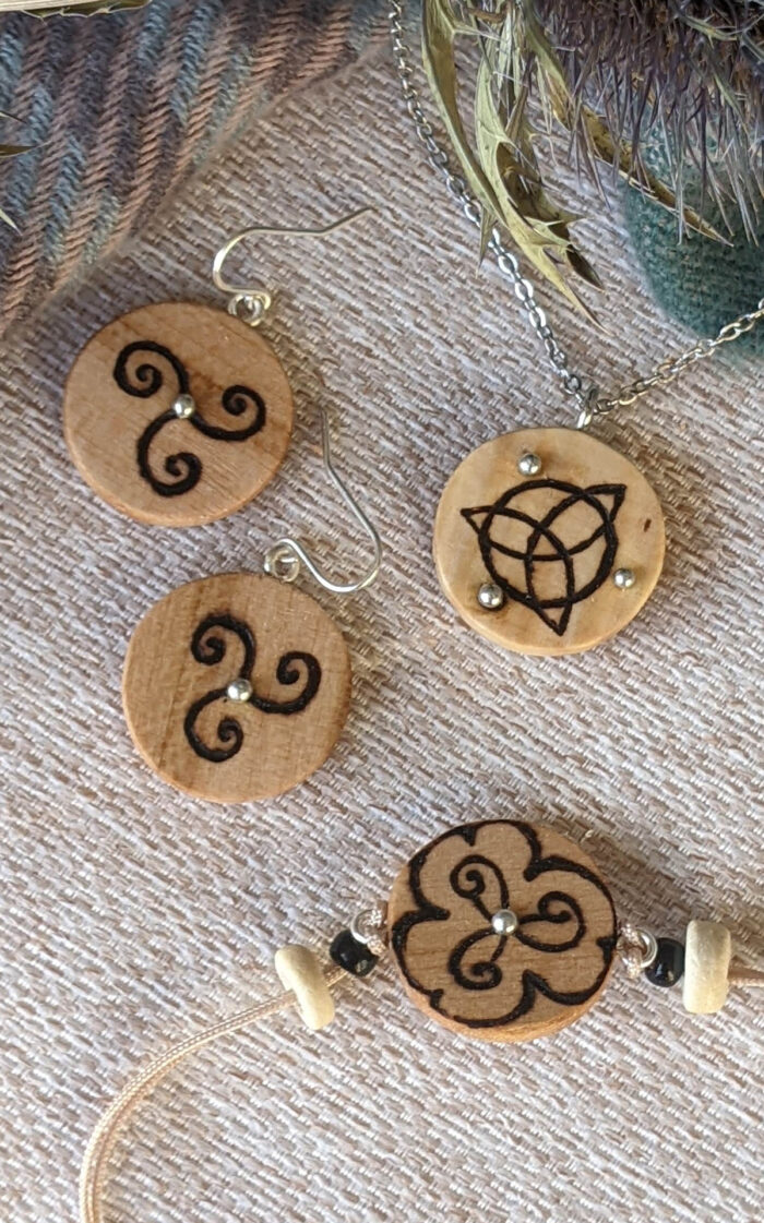bijoux en bois clair avec pyrogravure de symbole celtique, triketra, trisquel