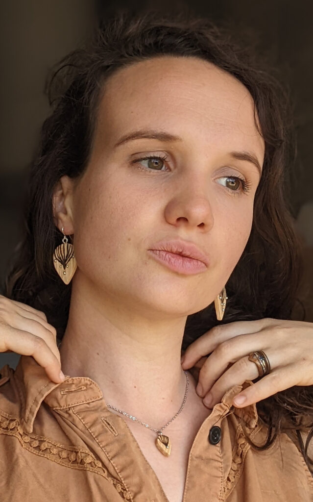 Femme portant des boucles d'oreilles en bois clair et pyrogravé